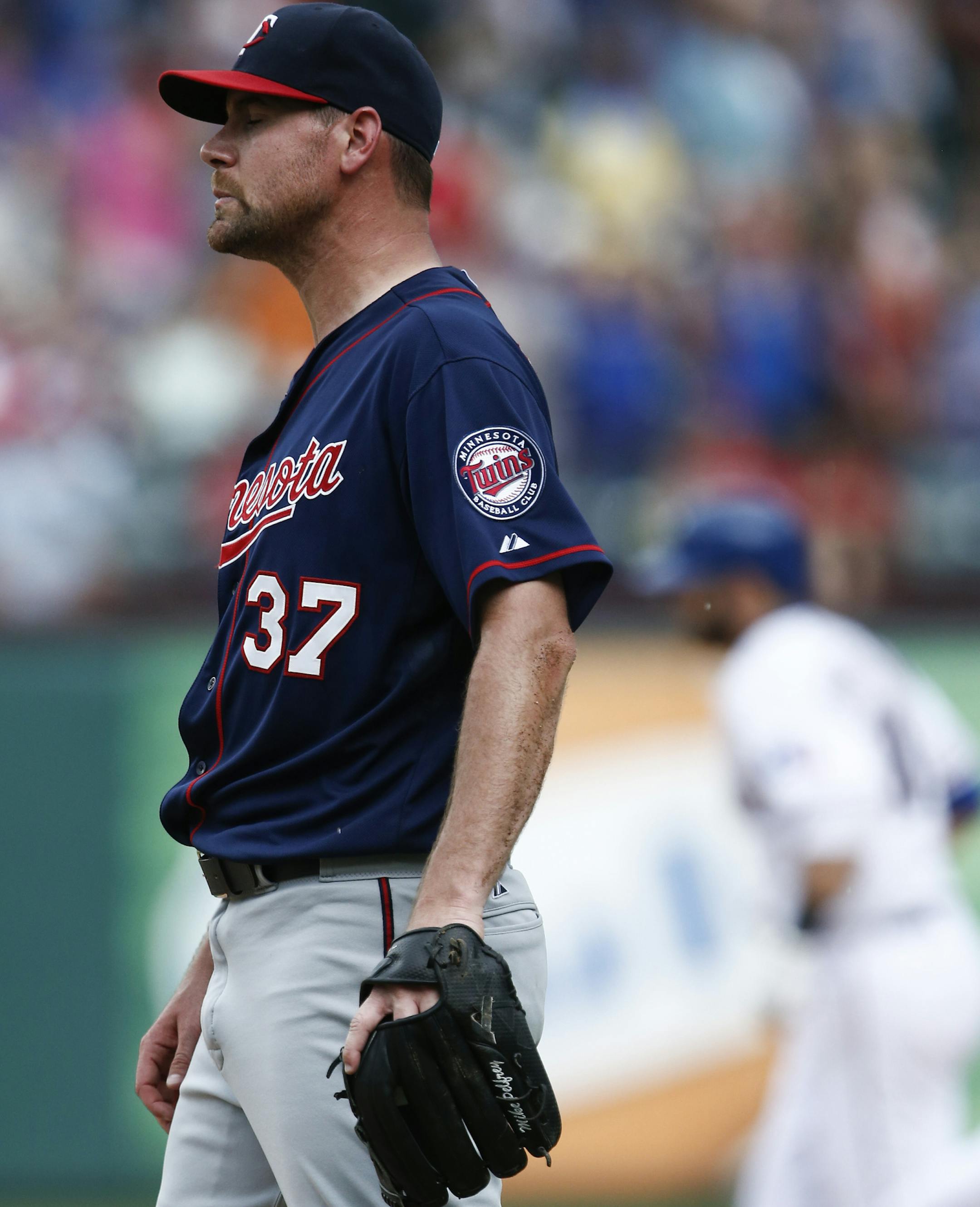 Minnesota Twins starting pitcher Mike Pelfrey (37) looks to the outfield as Texas Rangers' Mitch Moreland, right, circles the bases on his three-run home run during the fourth inning of a baseball game, Saturday, June 13, 2015, in Arlington, Texas. (AP Photo/Jim Cowsert)