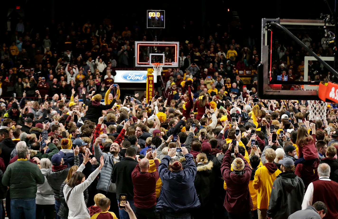 Minnesota fans storm the court after an upset victory over Ohio State