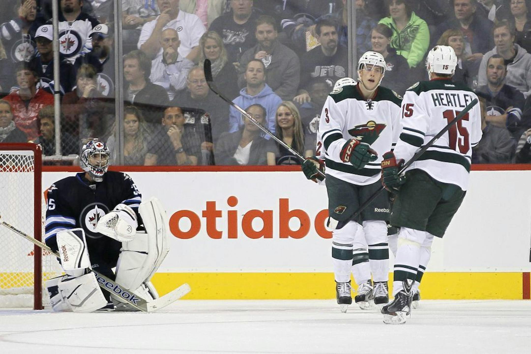 Minnesota Wild's Charlie Coyle (3) and Dany Heatley (15) celebrate Coyle's goal against Winnipeg Jets goaltender Al Montoya (35) during second-period preseason NHL hockey game action in Winnipeg, Manitoba, Thursday, Sept. 19, 2013.