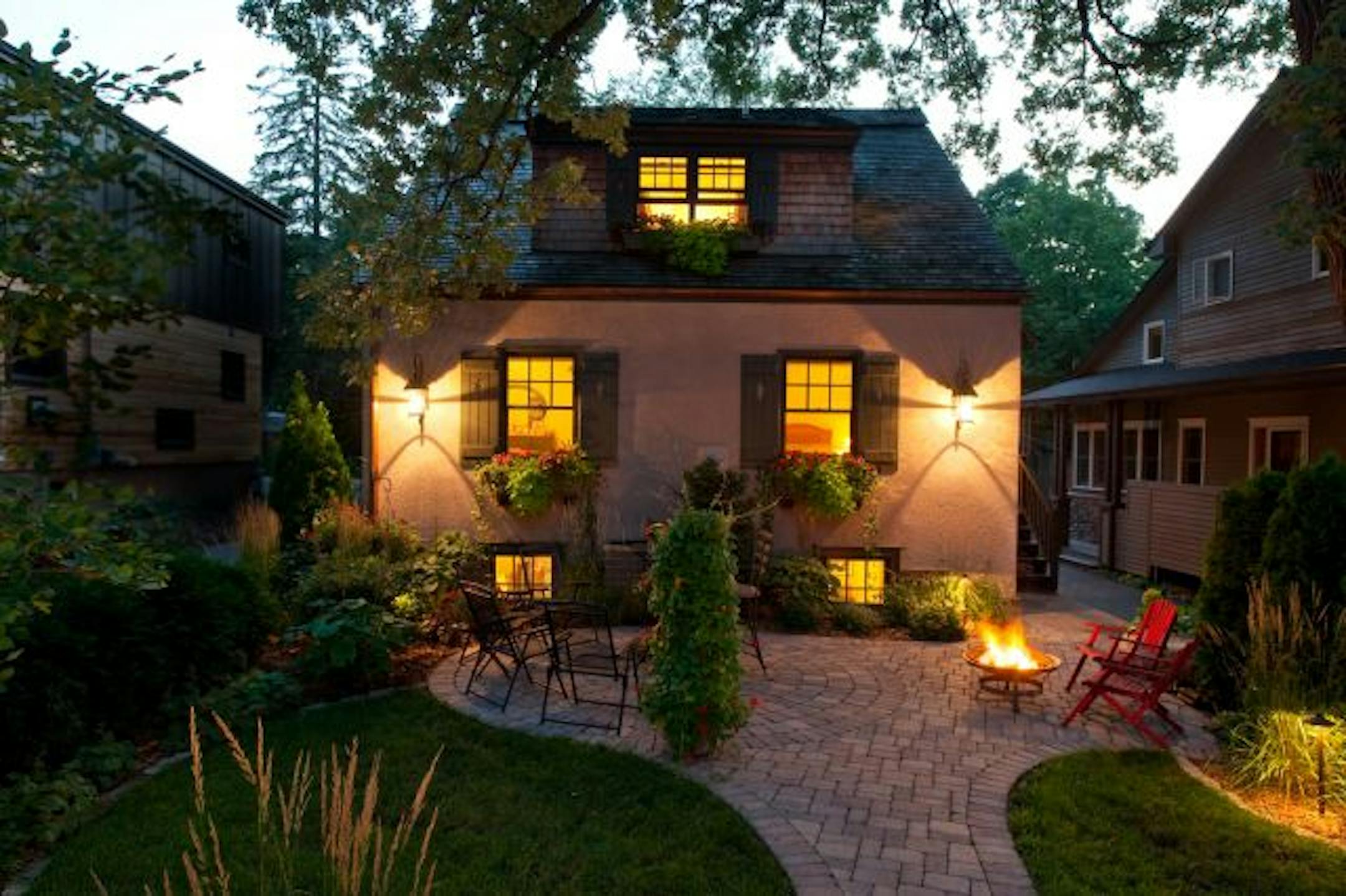 Every summer, the owners fill their window boxes with bright orange impatiens and host meals on their petite paver patio. The"little urban cottage" is dwarfed by its two neighbors.