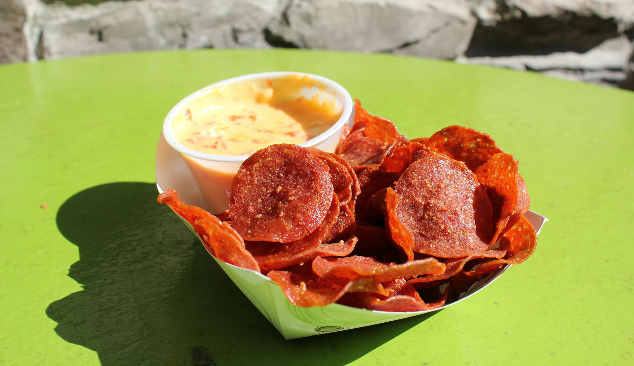 Pepperoni Chips with Roasted Red Pepper Queso: Thinly sliced fried pepperoni chips served with a warm roasted red pepper cheese sauce. At LuLu's Public House, located at West End Market, south of Schilling Amphitheater.