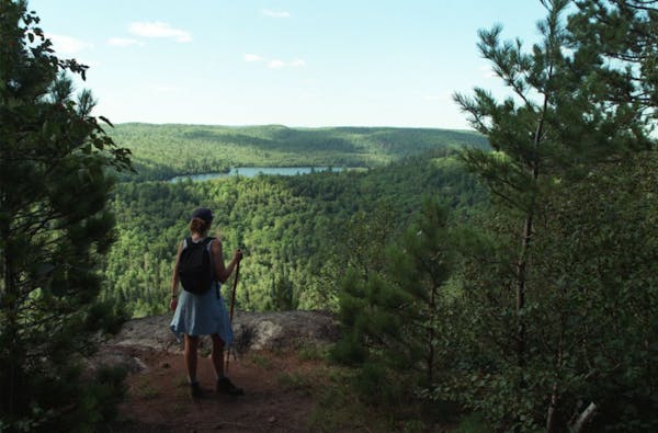 Minnesotans love hiking. Here a hiker pauses to appreciate the view while trekking the Superior Hiking Trail on Minnesota's North Shore.