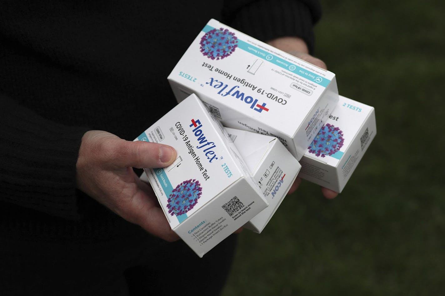 Teena McClelland holds four boxes of COVID tests outside of her home on April 28, 2022, in Chicago. McClelland has spent nearly a month trying to get free at-home COVID-19 tests at pharmacies through her insurance. (Stacey Wescott/Chicago Tribune/TNS) ORG XMIT: 47051822W