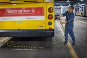 Metro Transit electrician Dan Aasen demonstrates how the electric buses are charged at the Metro Transit Heywood ] Elizabeth Flores • liz.flores@sta