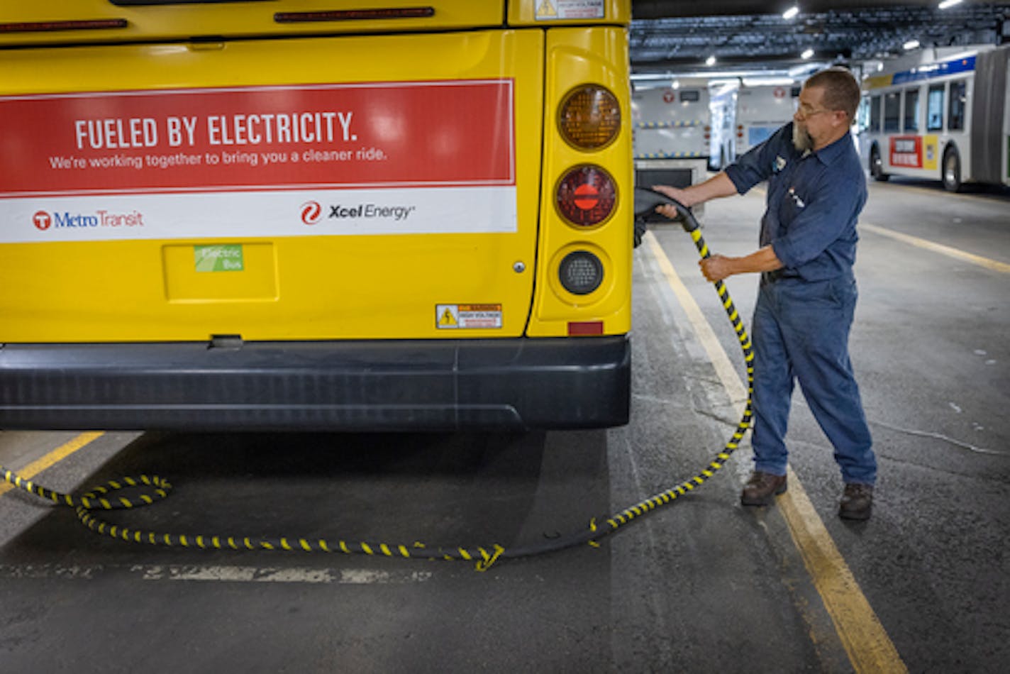 Metro Transit electrician Dan Aasen demonstrates how the electric buses are charged at the Metro Transit Heywood ] Elizabeth Flores • liz.flores@startribune.com