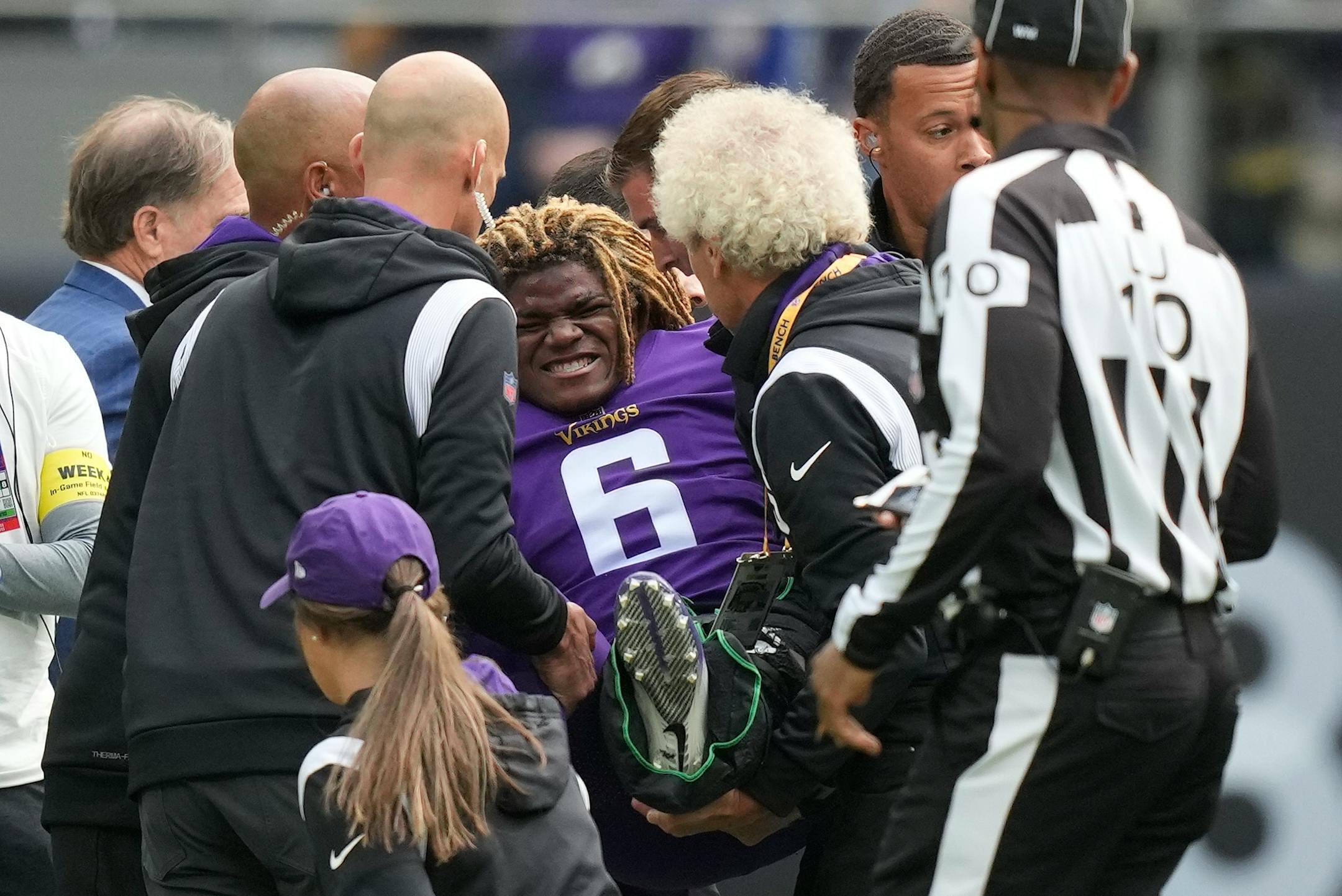 Minnesota Vikings safety Lewis Cine (6) grimaces as he receives treatment after an injury.