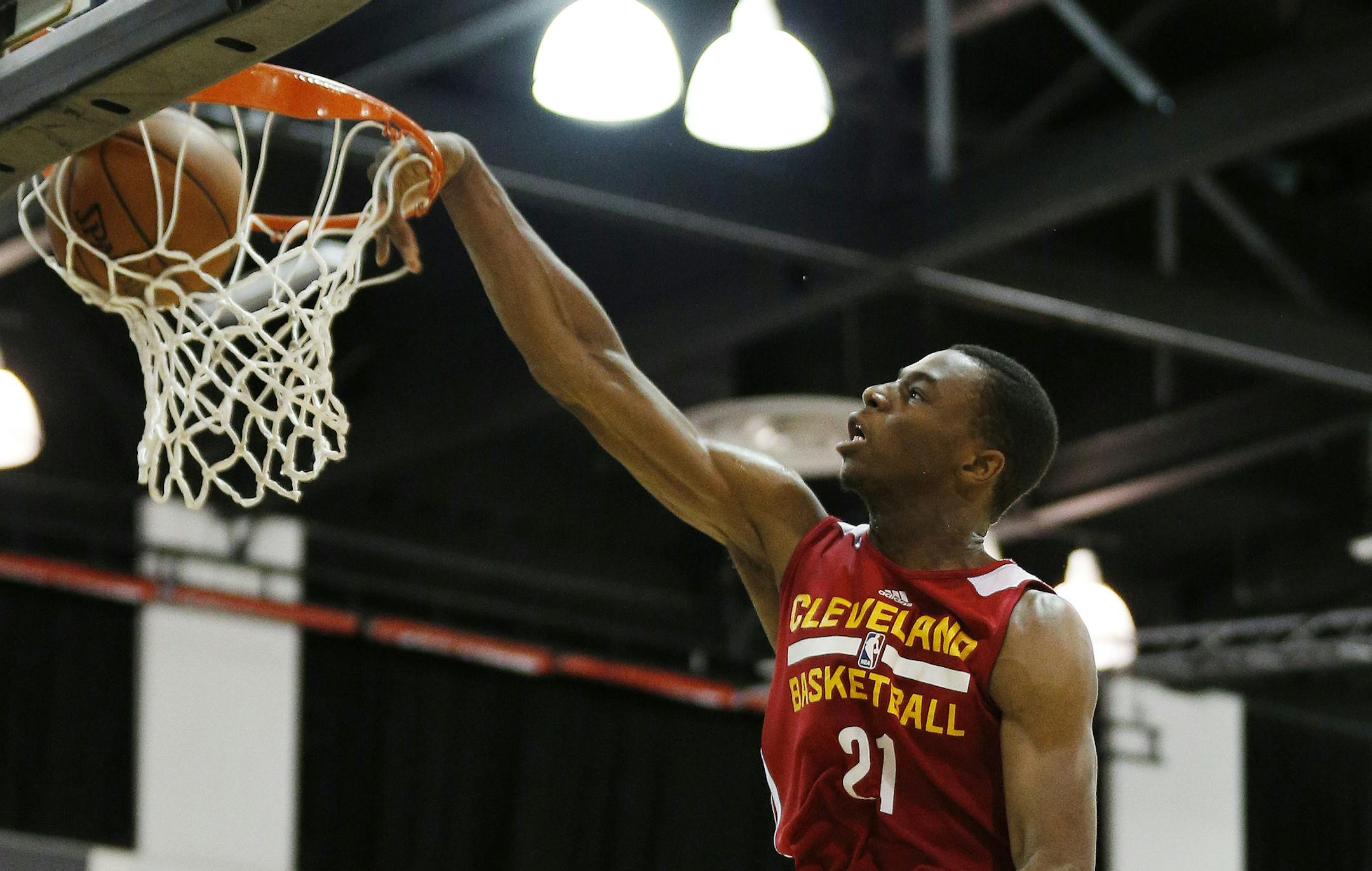 FILE - In this July 11, 2014, file photo, Cleveland Cavaliers' Andrew Wiggins, the No. 1 overall pick in the NBA draft, dunks against the Milwaukee Bucks during an NBA summer league basketball in Las Vegas. Wiggins will sign his rookie contract with the Cavaliers, an agreement that would prevent any potential trade involving the small forward from being completed for 30 days, a person familiar with the negotiations says. (AP Photo/John Locher, File)