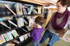 Eagan residents Nola McMahon, 7, and her mom Jessica McMahon found some books at the Wescott Library. Photo by Liz Rolfsmeier, Special to the Star Tri