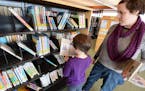 Eagan residents Nola McMahon, 7, and her mom Jessica McMahon found some books at the Wescott Library. Photo by Liz Rolfsmeier, Special to the Star Tri