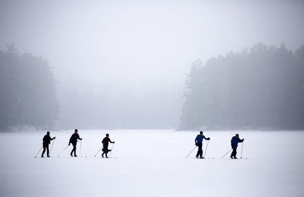 Members of the Minnesota Rovers Club ski across Lake Gegoka back to the Lodge after a morning on the trails. ] Historic National Forest Lodge BRIAN PE