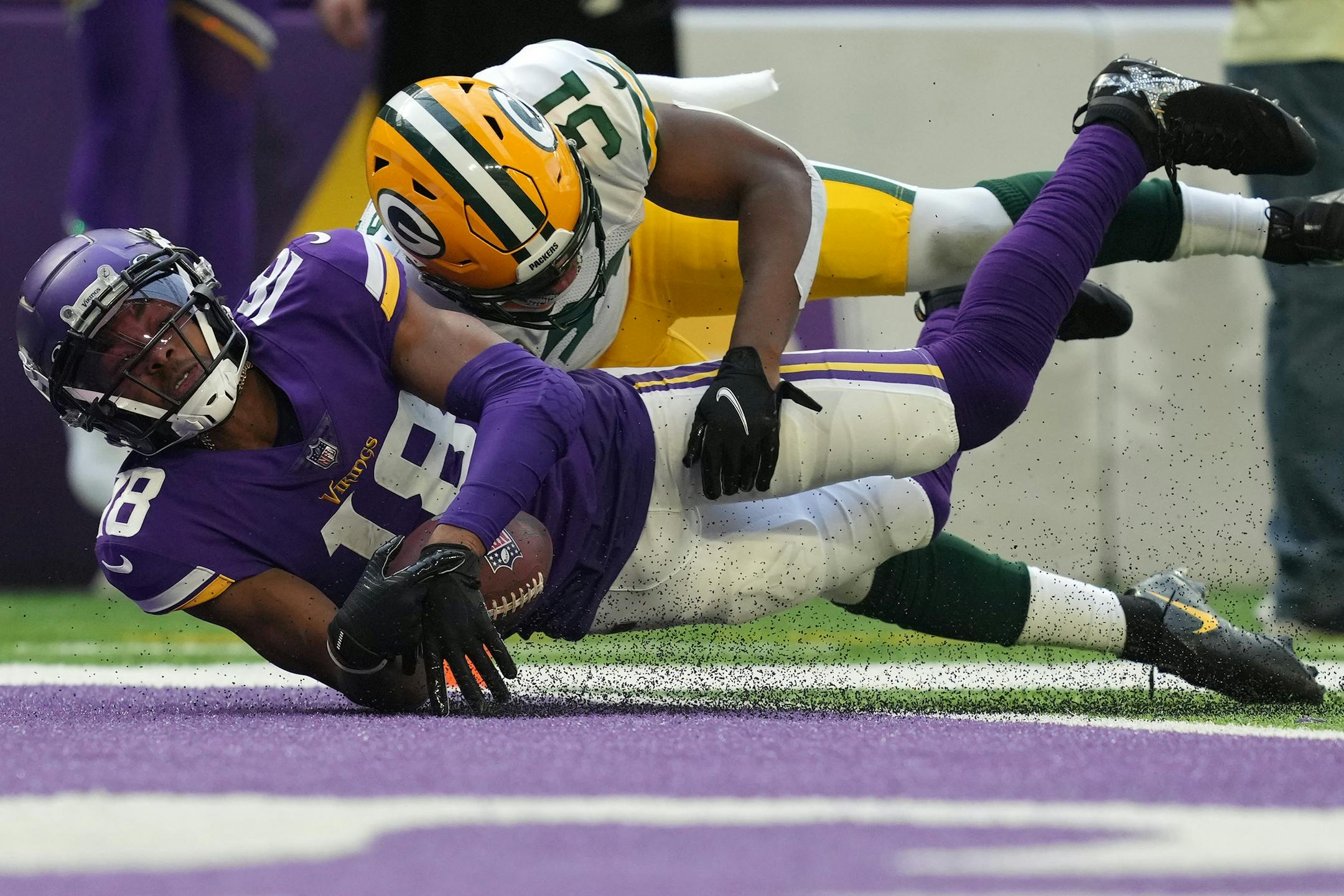 Minnesota Vikings wide receiver Justin Jefferson (18) was pulled down by Green Bay Packers safety Adrian Amos (31) just short of the goal line after he caught a long pass from quarterback Kirk Cousins (8) in the first quarter.