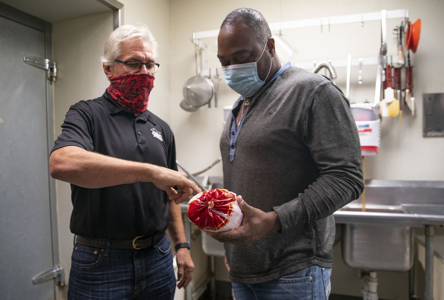 (Left) Tom Hanson handed Solomon Witherspoon a whole chicken for him to fry up with his family's secret recipe at OMC Grill on Monday. ] ALEX KORMANN • alex.kormann@startribune.com Popular Duluth restaurant owner Tom Hanson is mentoring two lifelong locals who plan to eventually open their own soul food restaurant in the city's burgeoning Lincoln Park neighborhood.