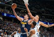 Nuggets center Nikola Jokic goes up for a shot as Wolves guard Monte Morris, front right, and forward Kyle Anderson defend Wednesday night in Denver. 