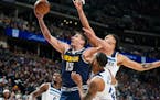 Nuggets center Nikola Jokic goes up for a shot as Wolves guard Monte Morris, front right, and forward Kyle Anderson defend Wednesday night in Denver. 