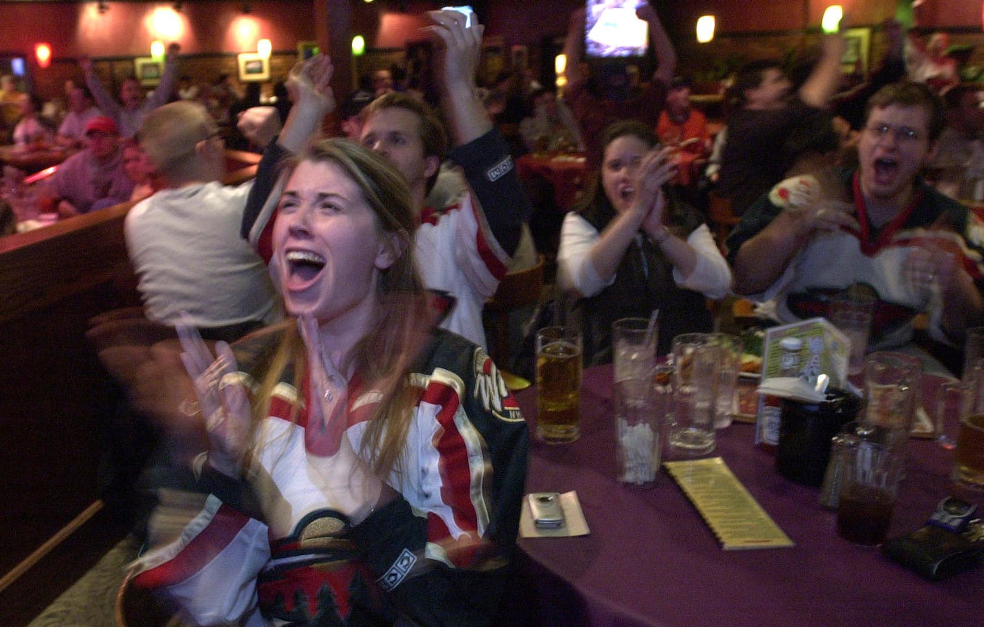 Tues April 22, 2003 -- Minnesota Wild vs. Colorado Avalanche pro hockey playoffs. Game seven in Colorado, these fans in Minnesota. Lisa Erickson and friends celebrate as Manny Fernandez makes a save during second period action at Joe Senser's Bar & Grill sports bar in Bloomington.