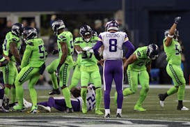 Vikings quarterback Kirk Cousins watches Seattle celebrate after stopping Latavius Murray on a third-quarter run in Seattle.