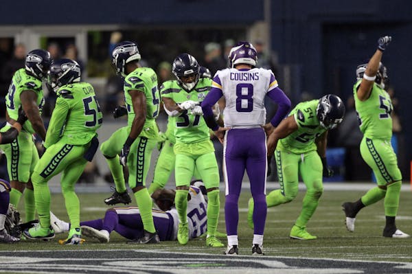 Vikings quarterback Kirk Cousins watches Seattle celebrate after stopping Latavius Murray on a third-quarter run in Seattle.