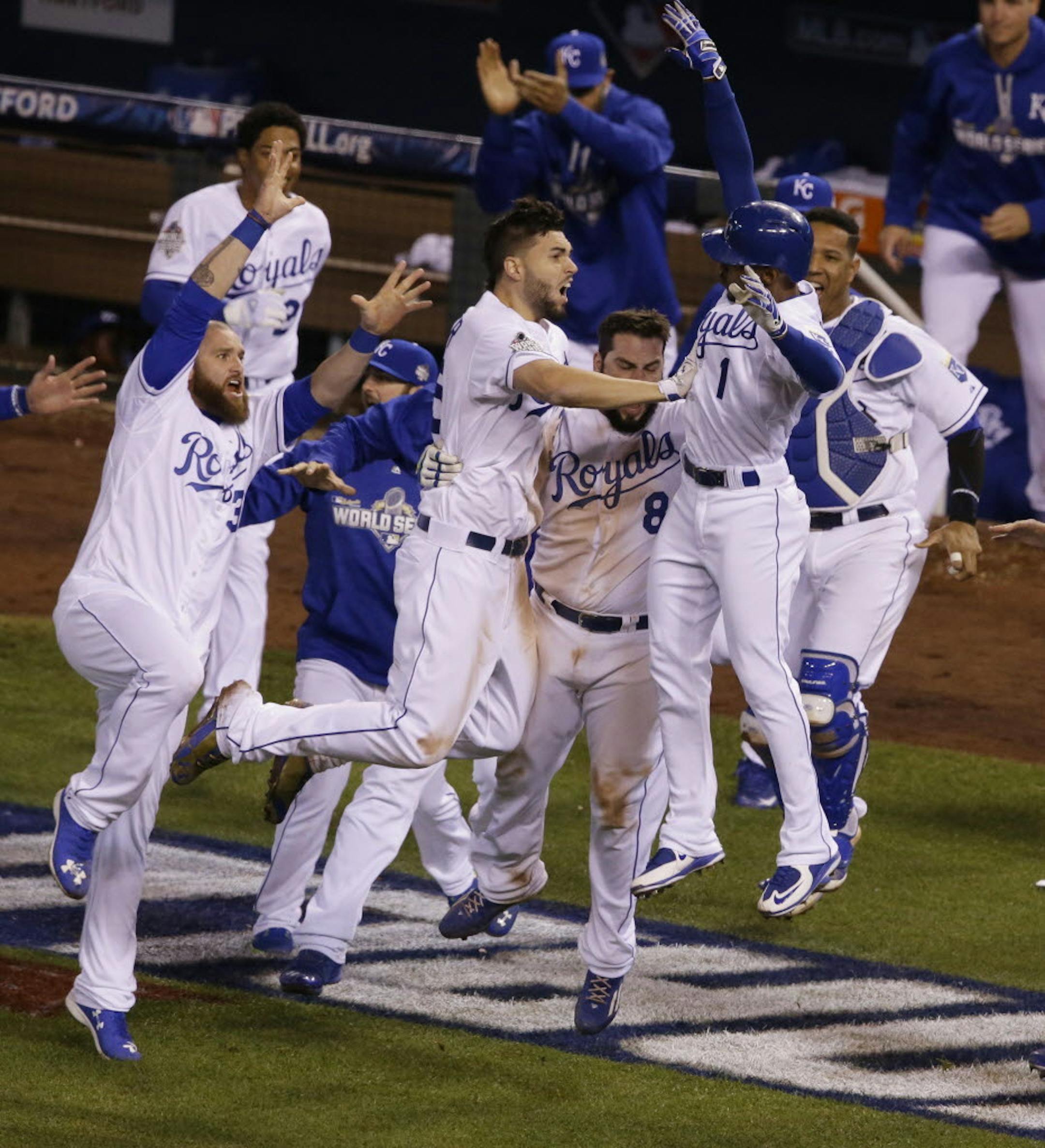 Kansas City Royals players celebrate after Alcides Escobar scored on a sacrifice fly by Eric Hosmer during the 14th inning of Game 1 of the Major League Baseball World Series against the New York Mets Wednesday, Oct. 28, 2015, in Kansas City, Mo.