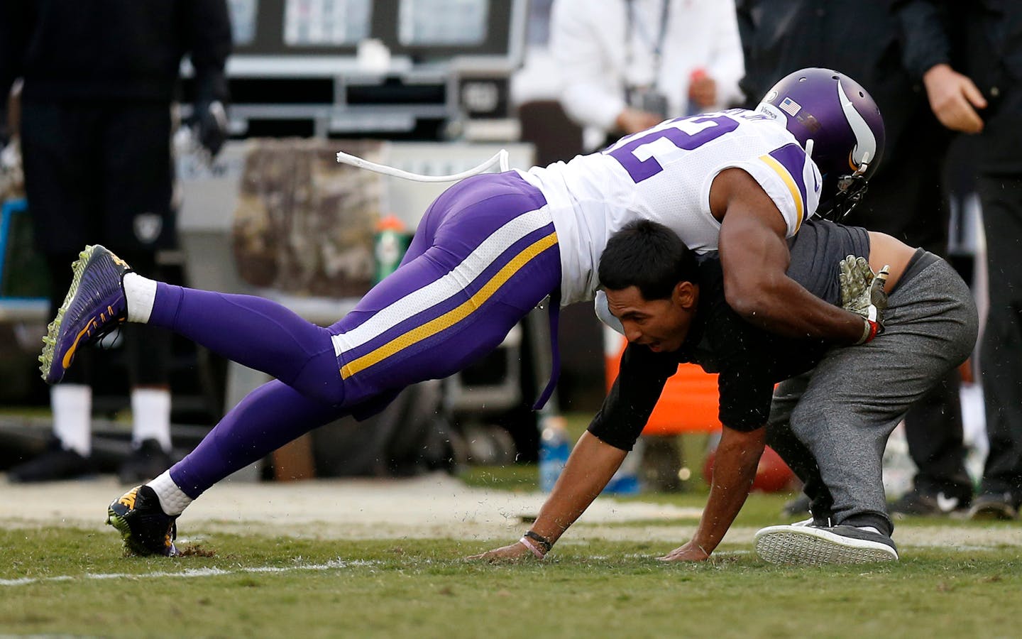 A football fan who ran onto the field is tackled by Minnesota Vikings' Antone Exum Jr. (32) during a fourth quarter time out on Sunday, Nov. 15, 2015, at O.co Coliseum in Oakland, Calif. (Nhat V. Meyer/Bay Area News Group/TNS) ORG XMIT: 1176691