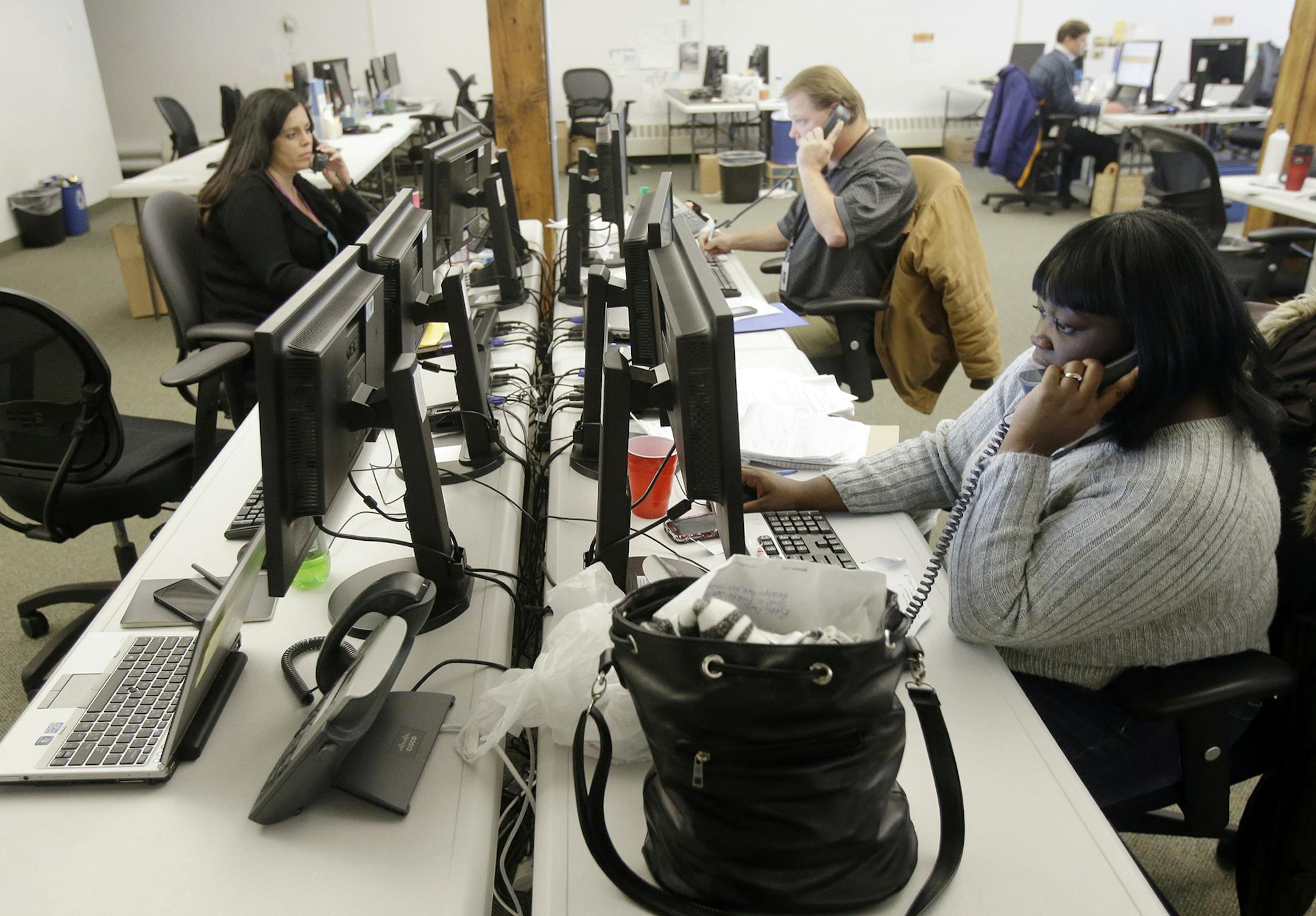 Guides work the phones Tuesday, Dec. 31, 2013, in St. Paul, Minn. for shoppers scrambling to finalize health coverage before the new year at Minnesota's insurance marketplace. The call center was the fallback for health insurance shoppers vexed by the troubled MNsure website. People who wanted to guarantee they'll be covered from Wednesday forward had to complete enrollment by Tuesday. (AP Photo/Jim Mone) ORG XMIT: MIN2014011016563052