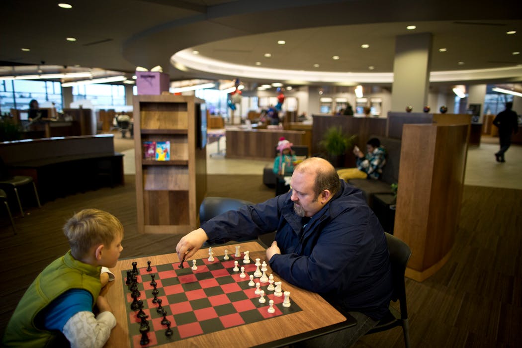 Shane Lourey of Mounds View taught his son Brady, 9, how to play chess as he waited for his new debit card to be made at Affinity Plus Fed Credit Union in Roseville in 2012.