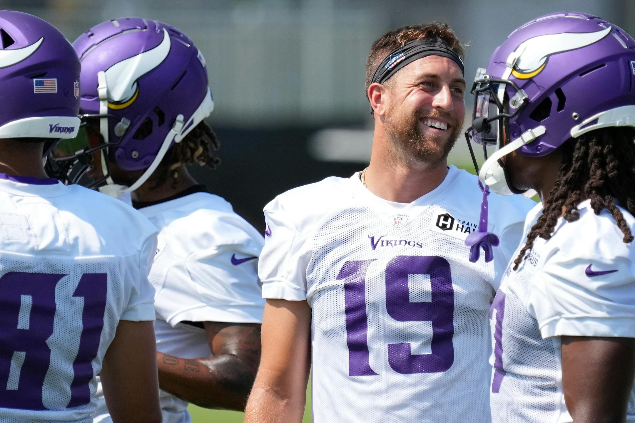 Minnesota Vikings wide receiver Adam Thielen (19) jokes with his teammates during training camp.