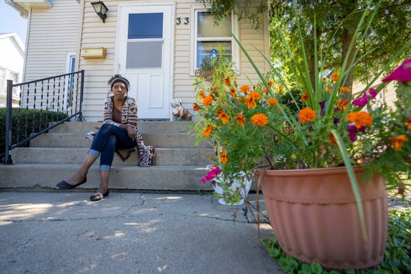 Laurie Thomas sits on the front step of her mother’s home in Freeport, Ill., where this past May floodwaters rose to the first step and inundated th