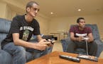 Filmon Haile, from Asmara, the capital city of Eritrea, in east Africa, left, plays a video game with Matt Michael, at his home on July 30, 2015 in Bo