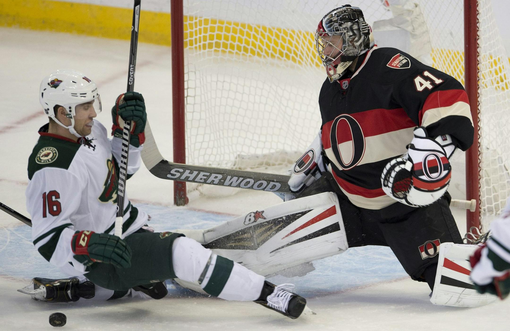 Minnesota Wild forward Jason Zucker, left, blocks a shot in front of Ottawa Senators goalie Craig Anderson during the first period of an NHL hockey game in Ottawa, Ontario on Wednesday, Nov. 20, 2013. (AP Photo/The Canadian Press, Adrian Wyld)