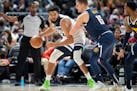 Timberwolves center Karl-Anthony Towns looks to pass the ball as Nuggets center Nikola Jokic defends in the second half