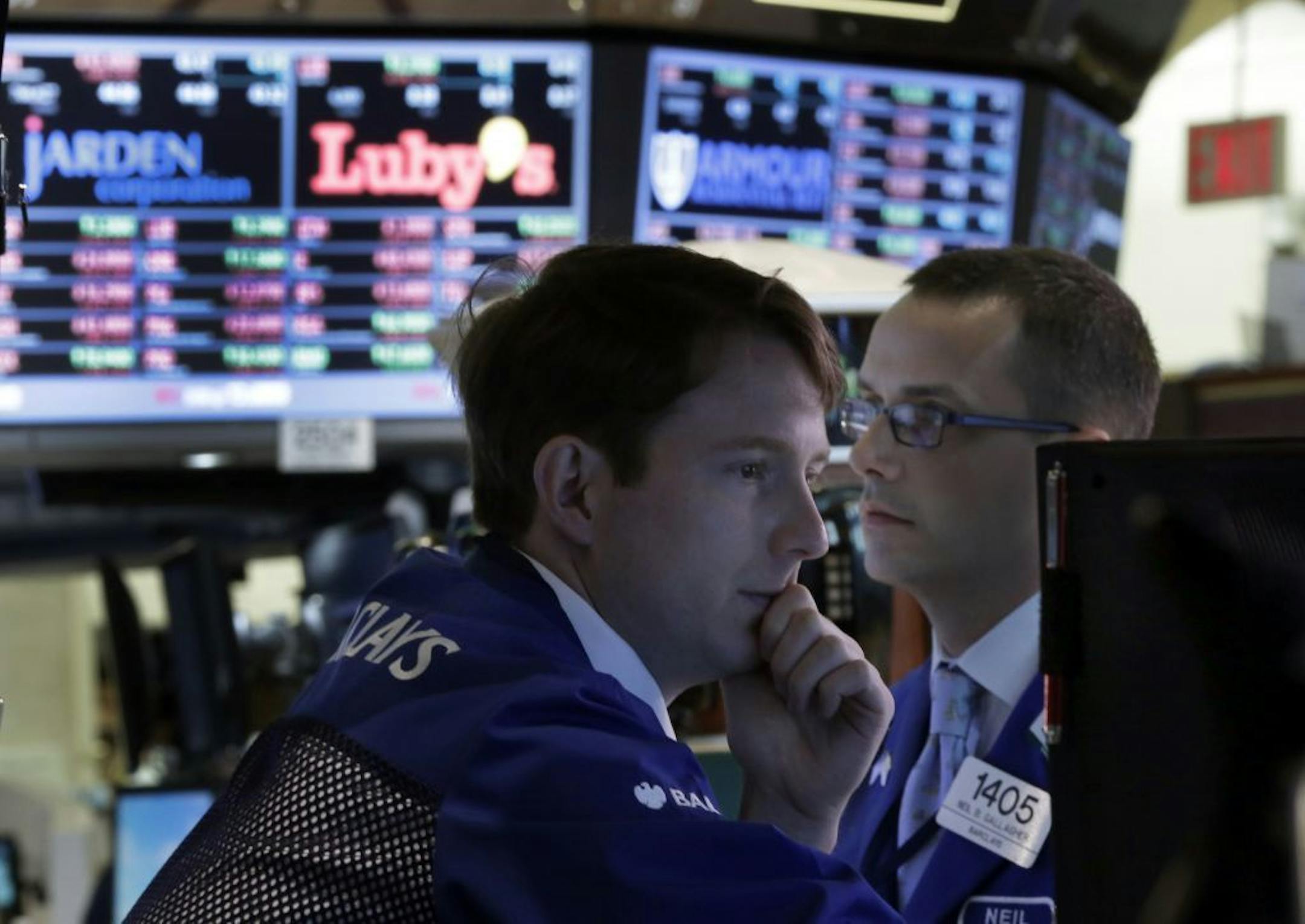 Specialists Peter Elkins, left, and Neil Gallagher work at their posts on the floor of the New York Stock Exchange, Thursday, June 20, 2013. Financial markets are sliding after the Federal Reserve said it could end its huge bond-buying program by the middle of next year.