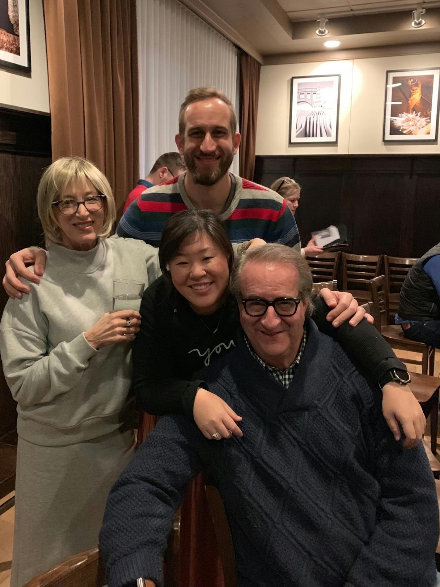 A family poses for a picture in what appears to be a restaurant.