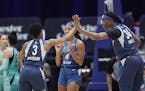 Minnesota Lynx guard Danielle Robinson (3) celebrates with center Sylvia Fowles (34) and Lexie Brown during the first half of the team's WNBA basketba