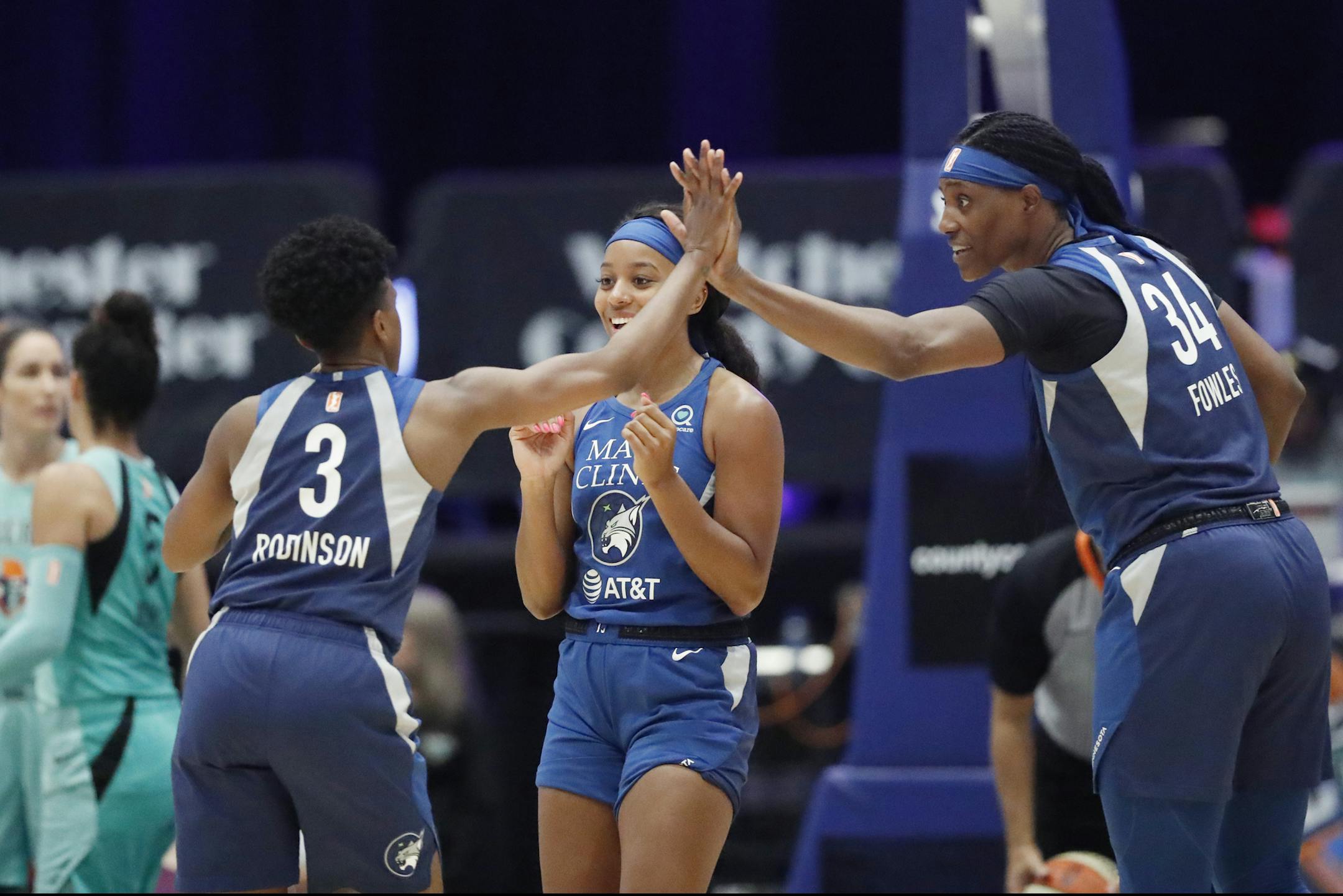 Minnesota Lynx guard Danielle Robinson (3) celebrates with center Sylvia Fowles (34) and Lexie Brown during the first half of the team's WNBA basketball game against the New York Liberty, Tuesday, Aug. 13, 2019, in White Plains, N.Y. The Lynx won 89-73. (AP Photo/Kathy Willens)