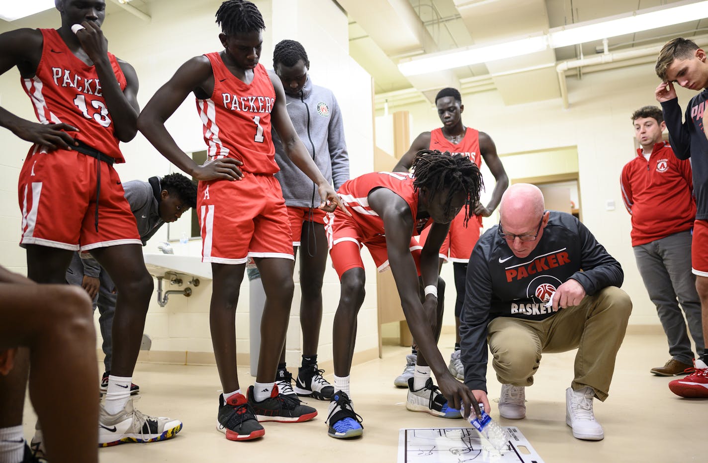 Austin head coach Kris Fadness talked things over with the team as senior Agwa Nywesh leaned over the white board to clarify one of the coaches directions during halftime against John Marshall. ] Aaron Lavinsky &#x2022; aaron.lavinsky@startribune.com Photos to accompany a feature on the ethnic diversification of Austin Minn., as seen through the Austin High School boys basketball and soccer programs, photographed Tuesday, Dec. 17, 2019.