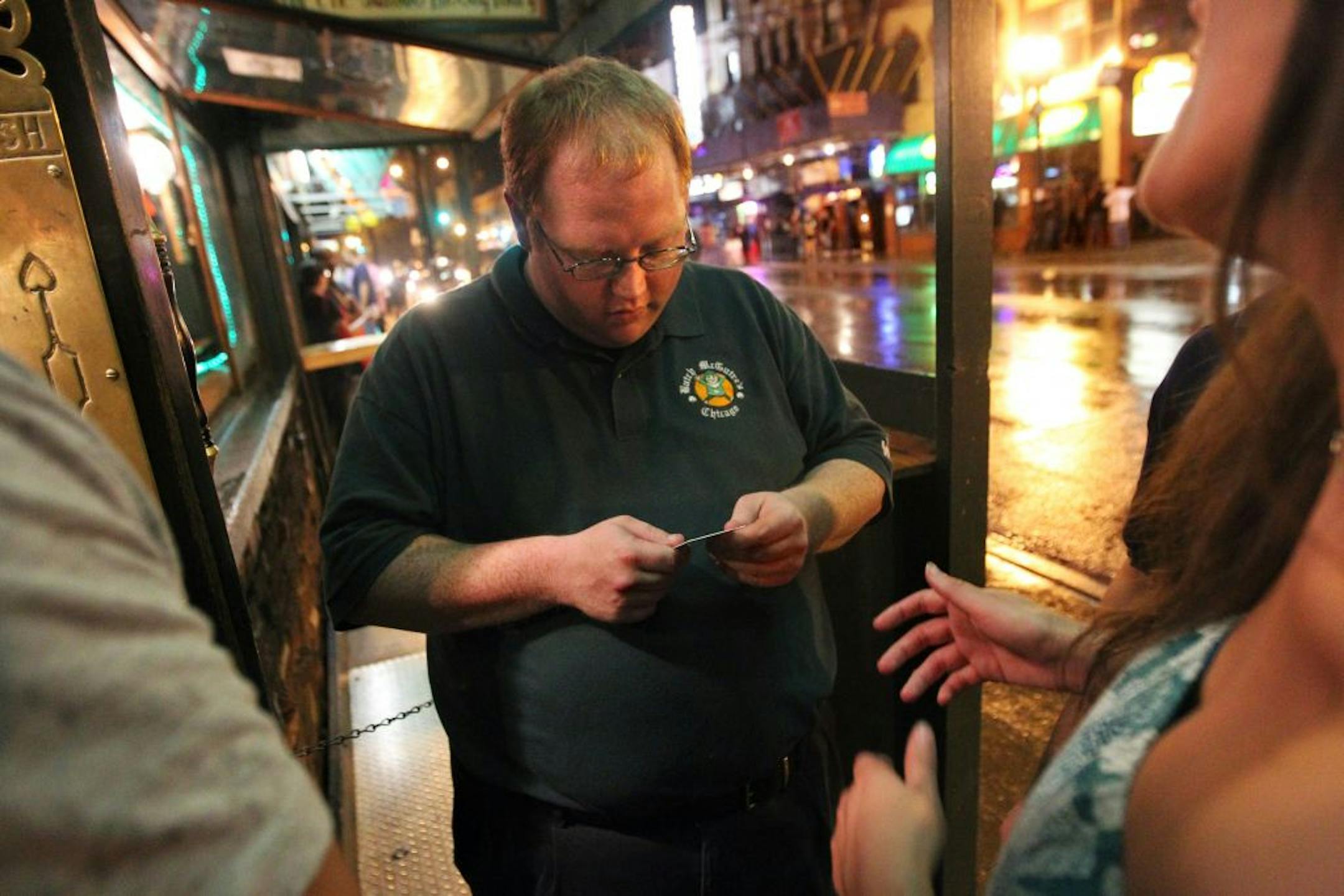 Is it real or a very good fake? Doorman John Malloy checked an ID at Butch McGuire's bar in Chicago. Fake IDs for underage drinkers have become an international business.