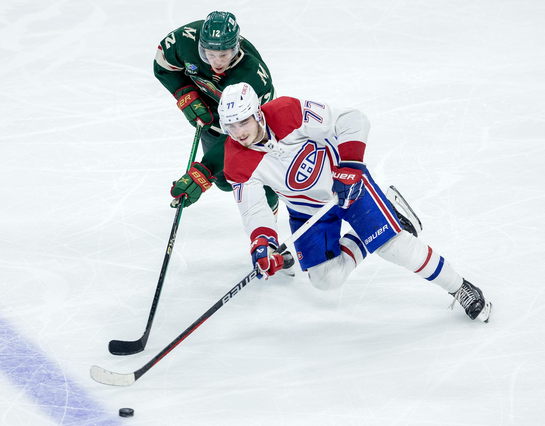 Matt Boldy (12) of the Minnesota Wild and Kirby Dach (77) of the Montreal Canadiens fight for the puck in the third period.