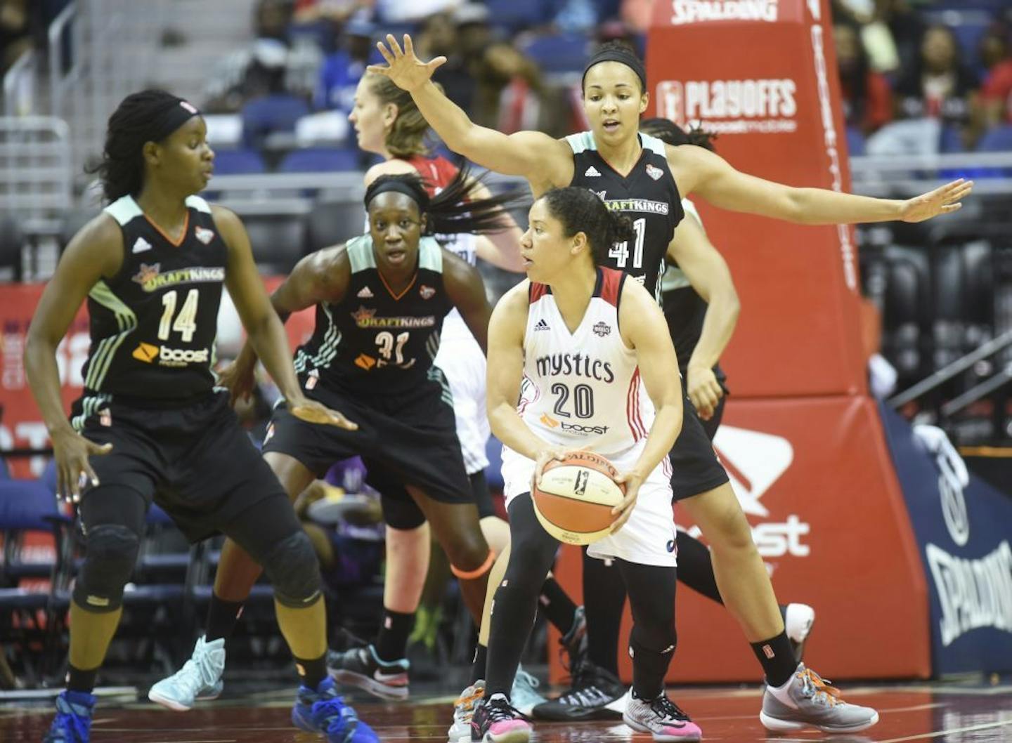 Washington Mystics' Kara Lawson (20) is surrounded by New York Liberty's Sugar Rodgers (14), Tina Charles (31) and Kiah Stokes (41) during the second half of a WNBA basketball playoff game on Sunday, Sept. 20, 2015, in Washington.