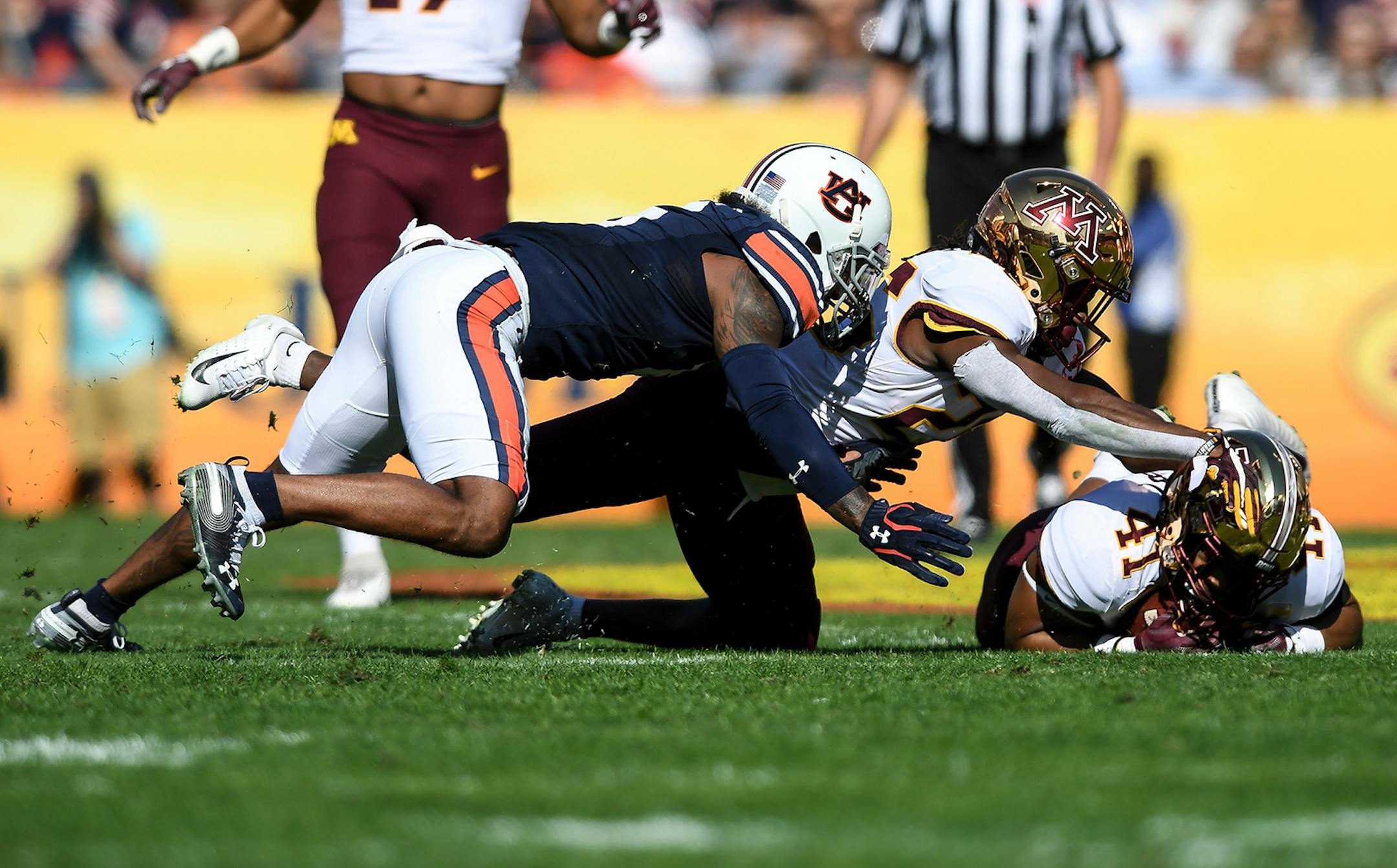 Auburn Tigers defensive back Christian Tutt (6) fumbled the ball, leading to a recovery by Minnesota Gophers linebacker Thomas Barber (41) in the first quarter.