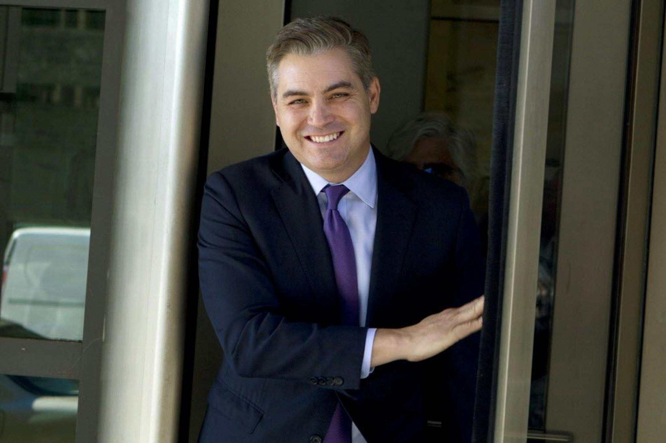 CNN's Jim Acosta walks out of the U.S. District Courthouse with a smile, Friday, Nov. 16, 2018, in Washington. U.S. District Court Judge Timothy Kelly ordered the White House to immediately return Acosta's credentials. He found that Acosta was "irreparably harmed" and dismissed the government's argument that CNN could send another reporter in Acosta's place to cover the White House.