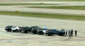 Squad cars were on the tarmac at the Twin Cities airport, where a flight left Wednesday to take the body of Minneapolis police officer Jamal Mitchell 