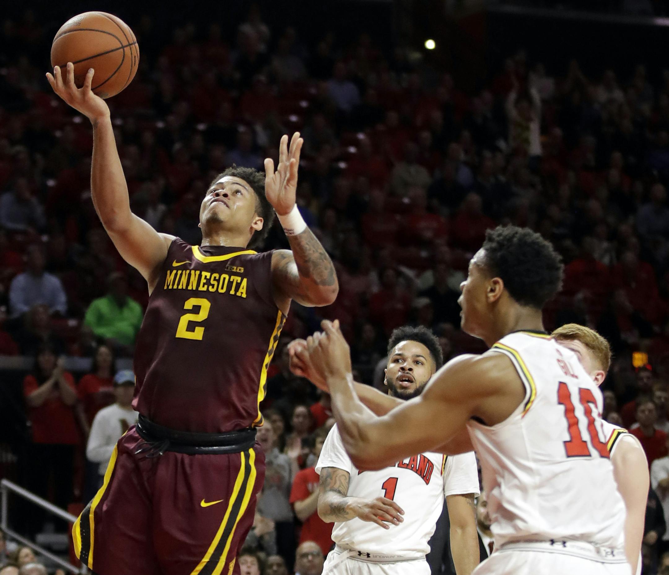 Minnesota guard Nate Mason (2) shoots over Maryland guard Jaylen Brantley (1) and forward L.G. Gill (10) during the first half of an NCAA college basketball game, Wednesday, Feb. 22, 2017, in College Park, Md. (AP Photo/Patrick Semansky)