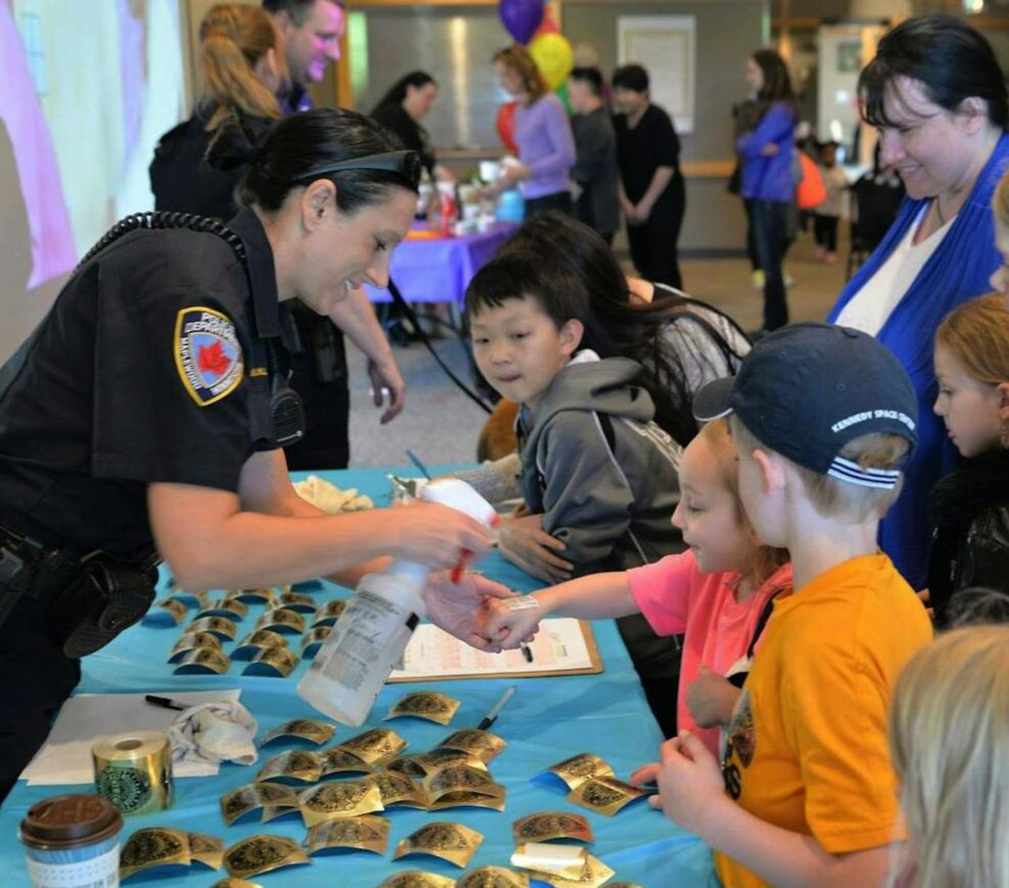 Maplewood police officers swap jokes for temporary tattoos at the 2016 Laugh-In event, held at the Maplewood YMCA.