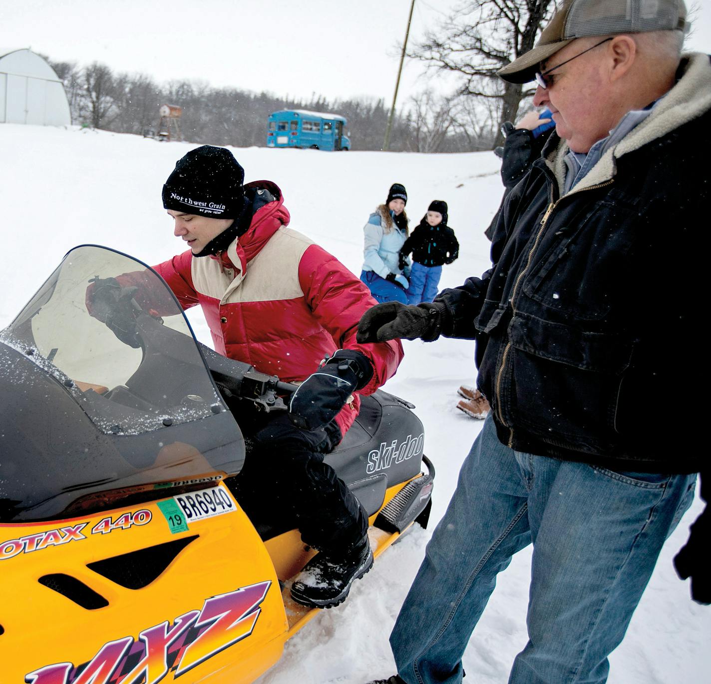 The Ingrahams have taken to Minnesota life, including snowmobiling. Longtime resident Dick Brumwell shows where the brakes are. Sons Jack and Charlie meet the band at a basketball game.