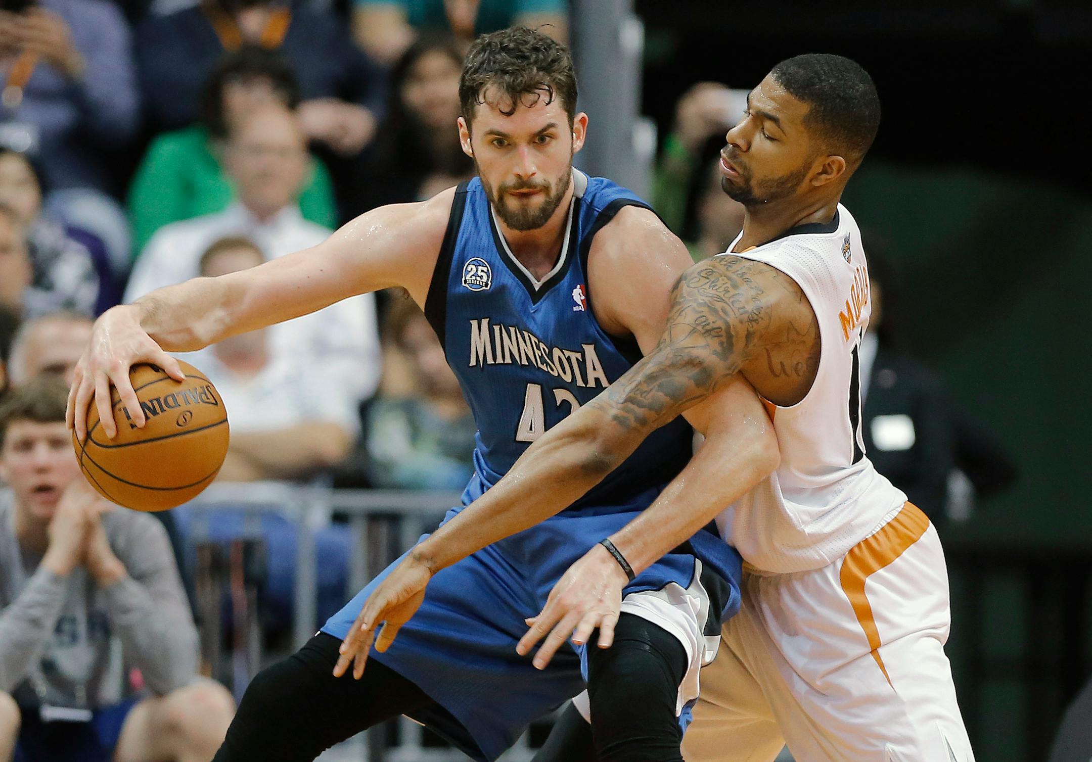 Minnesota Timberwolves forward Kevin Love, left, backs down Phoenix Suns forward Markieff Morris during the second half of an NBA basketball game, Tuesday, Feb. 25, 2014, in Phoenix. (AP Photo/Matt York)