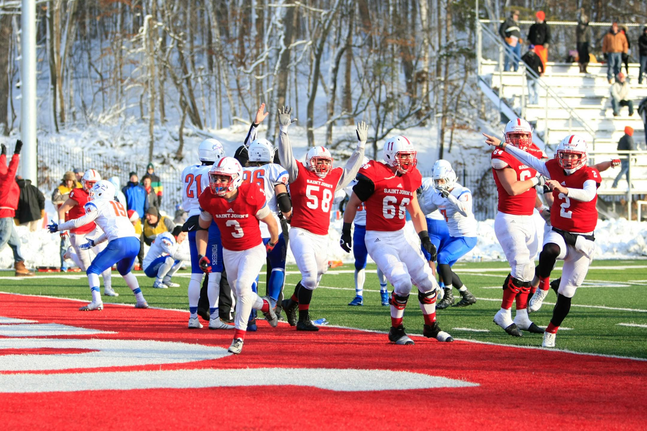 The Johnnies celebrate Dusty Krueger's (3) one-yard touchdown run on the game's final play, fourth-and-goal, in SJU's 32-31 win over UW-Platteville on November 19.