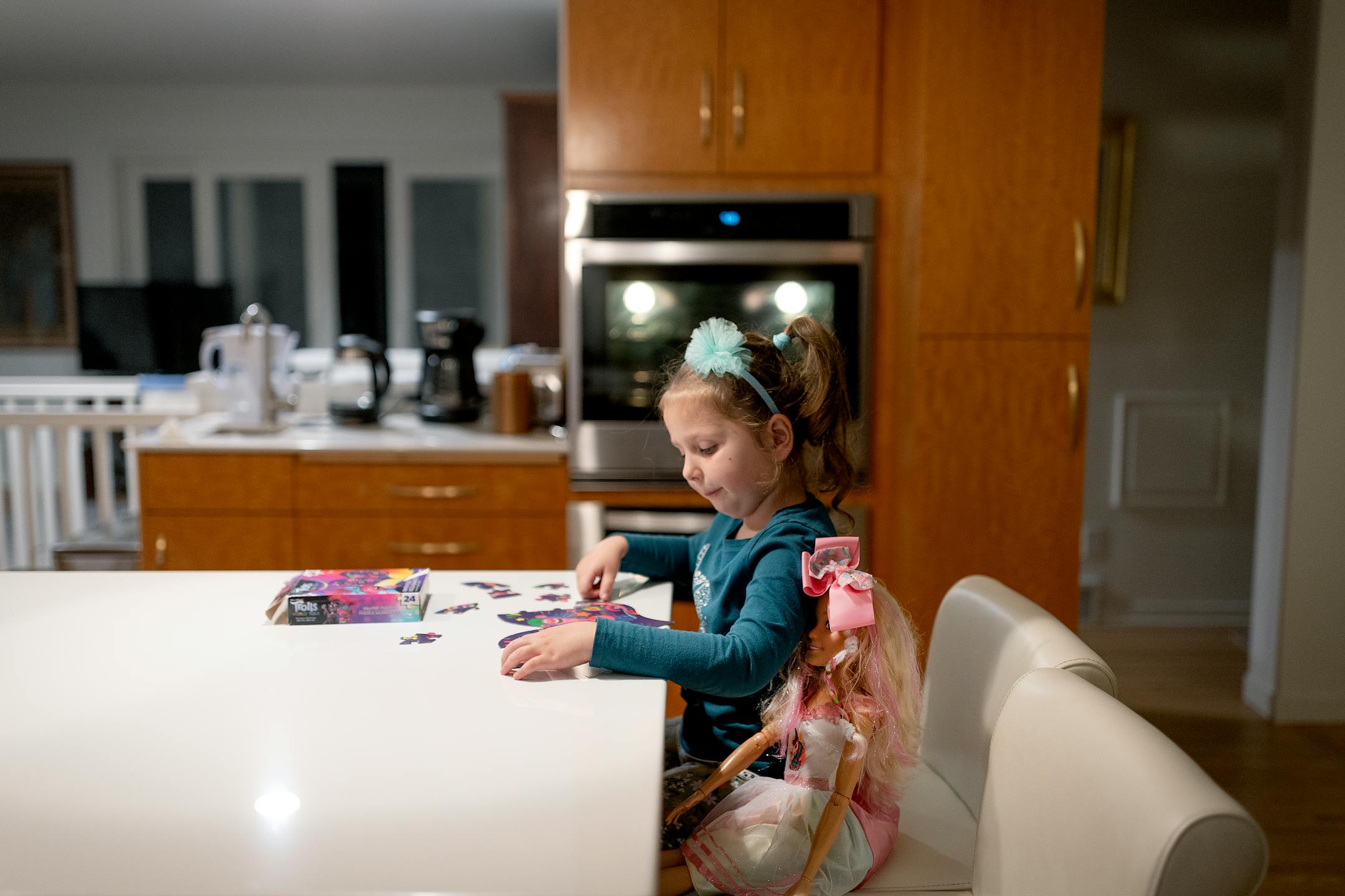Natalia Kuchma's five-year-old daughter Solomiia, sits quietly working on a puzzle with the doll she received after learning how to write her name at their host home in Minneapolis.