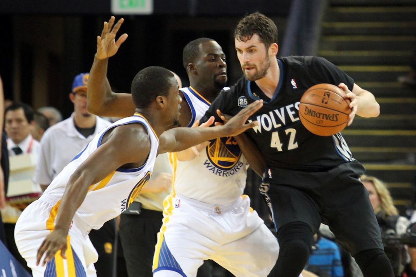 The Golden State Warriors' Harrison Barnes, left, and Draymond Green (23) pressure the Minnesota Timberwolves' Kevin Love (42) in the first half at the Oracle Arena in Oakland, Calif., on Friday, Jan. 24, 2014.