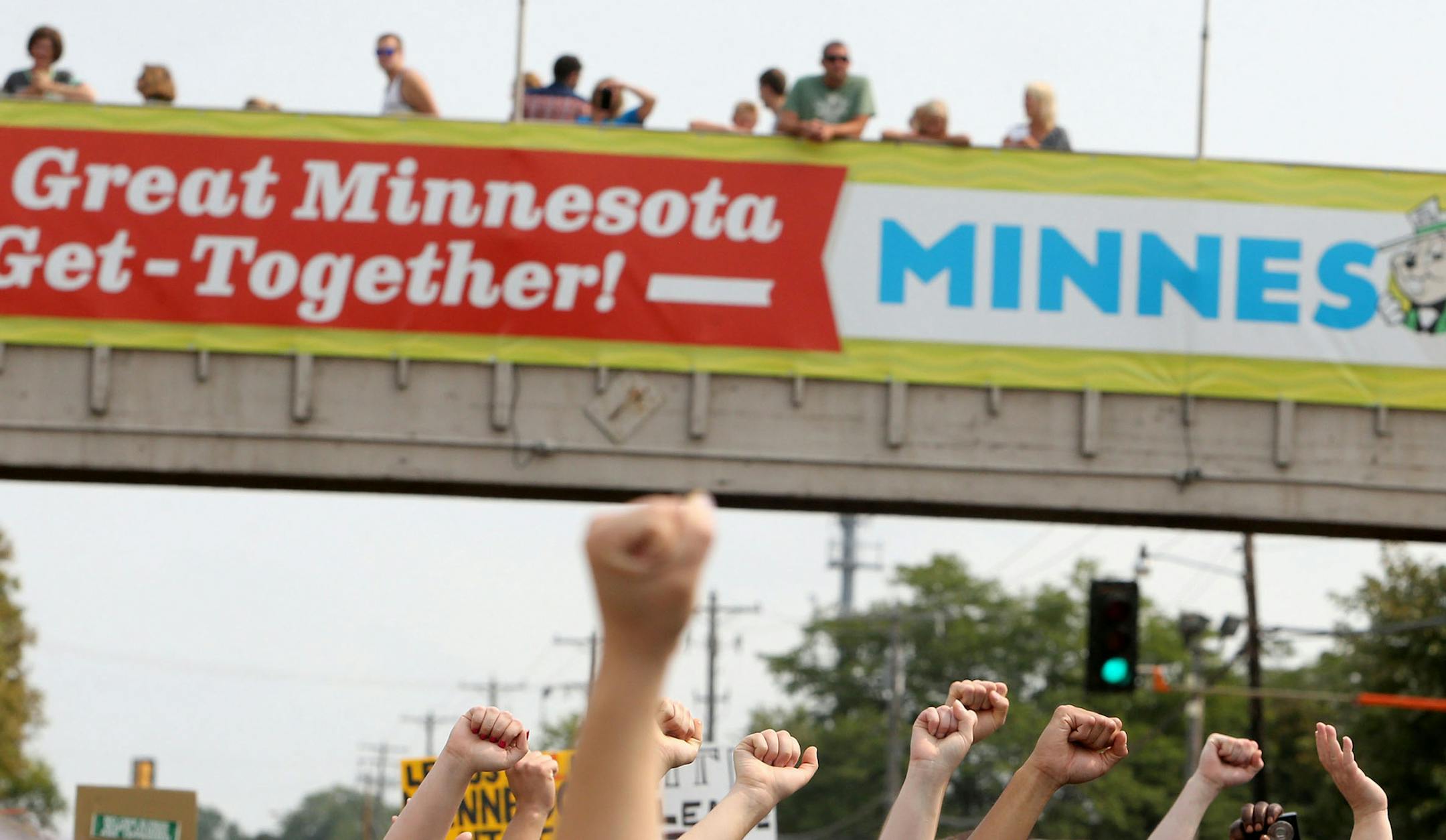 Black Lives Matter Minnesota vows to disrupt the State Fair's first Saturday by assembling at Hamline Park and marching to the Minnesota State Fairgrounds entrance Saturday, Aug. 29, 2015, in St. Paul. Here, Black Lives Matter protestors raise their fists beneath a pedestrian walk bridge at the state fairgrounds. ](DAVID JOLES/STARTRIBUNE)djoles@startribune.com Black Lives Matter Minnesota vows to disrupt State Fair's first Saturday by assembling at Hamline Park and marching to the fairgrounds e