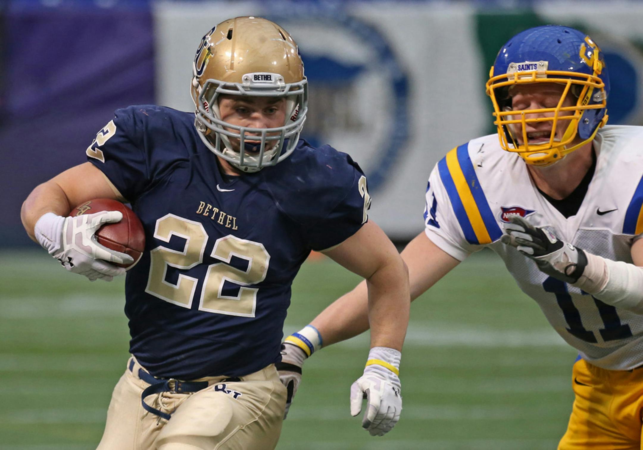 Bethel running back Brandon Marquardt evaded the tackle of St. Scholastica's Paul Olson during Saturday's first-round game. Bethel won 70-13.